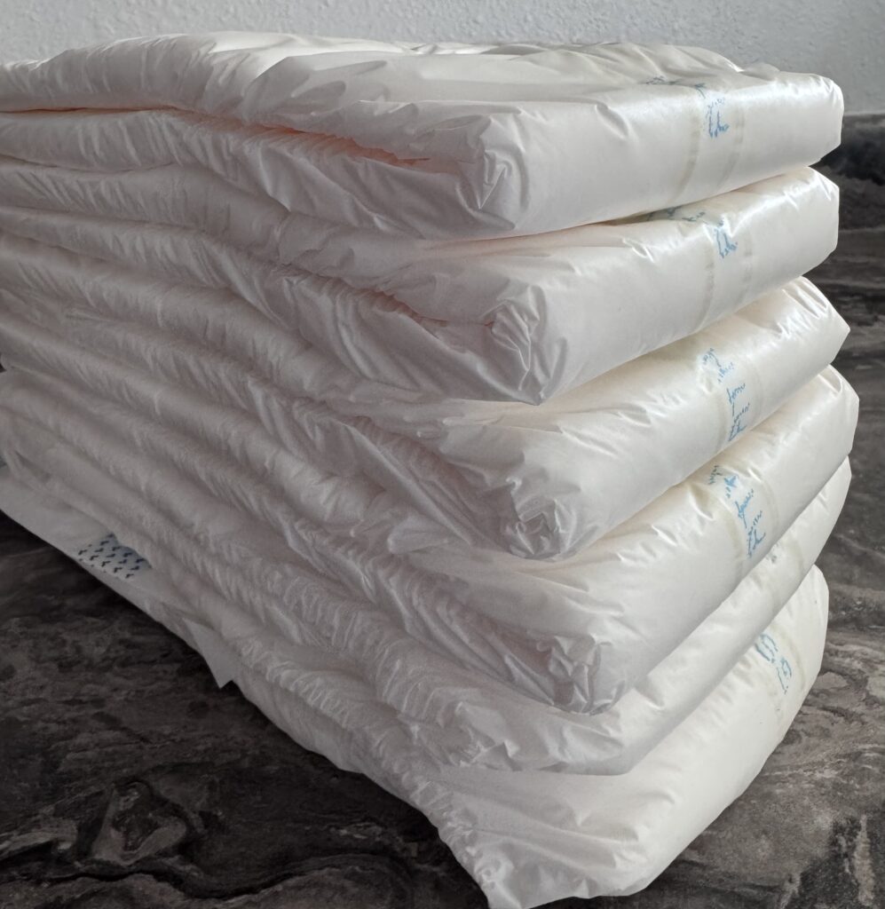 stack of six Tranquility ATN adult diapers showing thickness and bulk